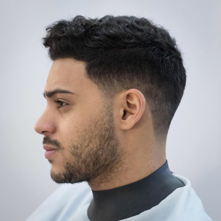 a low fade haircut is a stylish idea to rock naturlaly curly hair