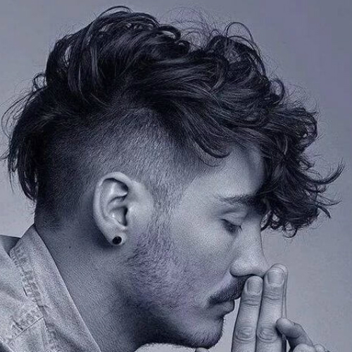 a curly mohawk is for those who love a contrast between the sides and the top