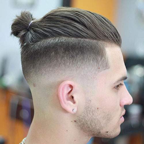 a line up with long hair and undercut fade sides plus a man bun on top for an edgy look