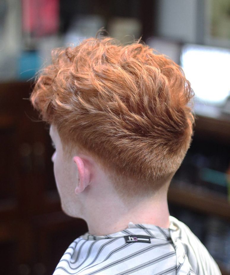 a medium length curly haircut and a low fade is a bold modern option