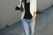 With black top, distressed jeans, black pumps and black clutch