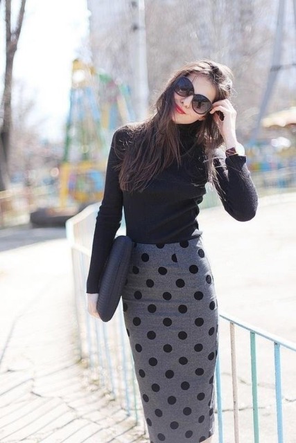 With black turtleneck and clutch