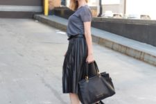 With gray shirt, black ankle boots and black tote bag