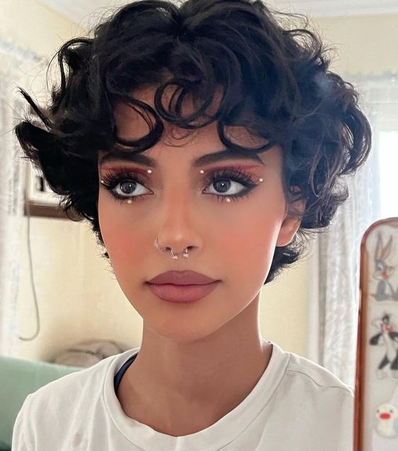 a beautiful long black curly pixie haircut with bangs and volume is a stylish and catchy idea