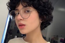 a black curly long pixie haircut with long bangs and some volume looks fresh, cool and modern