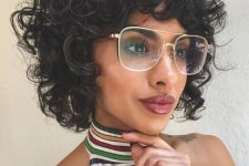 a chin-length curly black bob haircut with bangs is a supr cool and bold idea to try right now