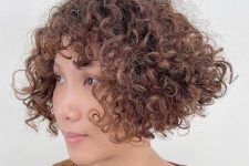 a curly inverted bob with short bangs gives a beautifully crafted shape to make the hair look wider and fuller