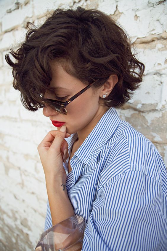 a jaw-length curly bob with long bangs done in dark brunette is a super cool and bold solution
