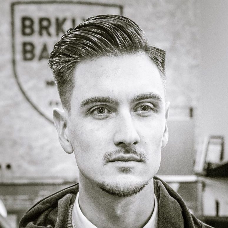 a side part haircut features a part for over to one side and a high fade, add pomade