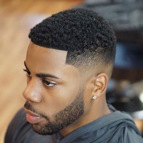 a bald fade, short kinky hair and a full beard are a modern and edgy idea to try