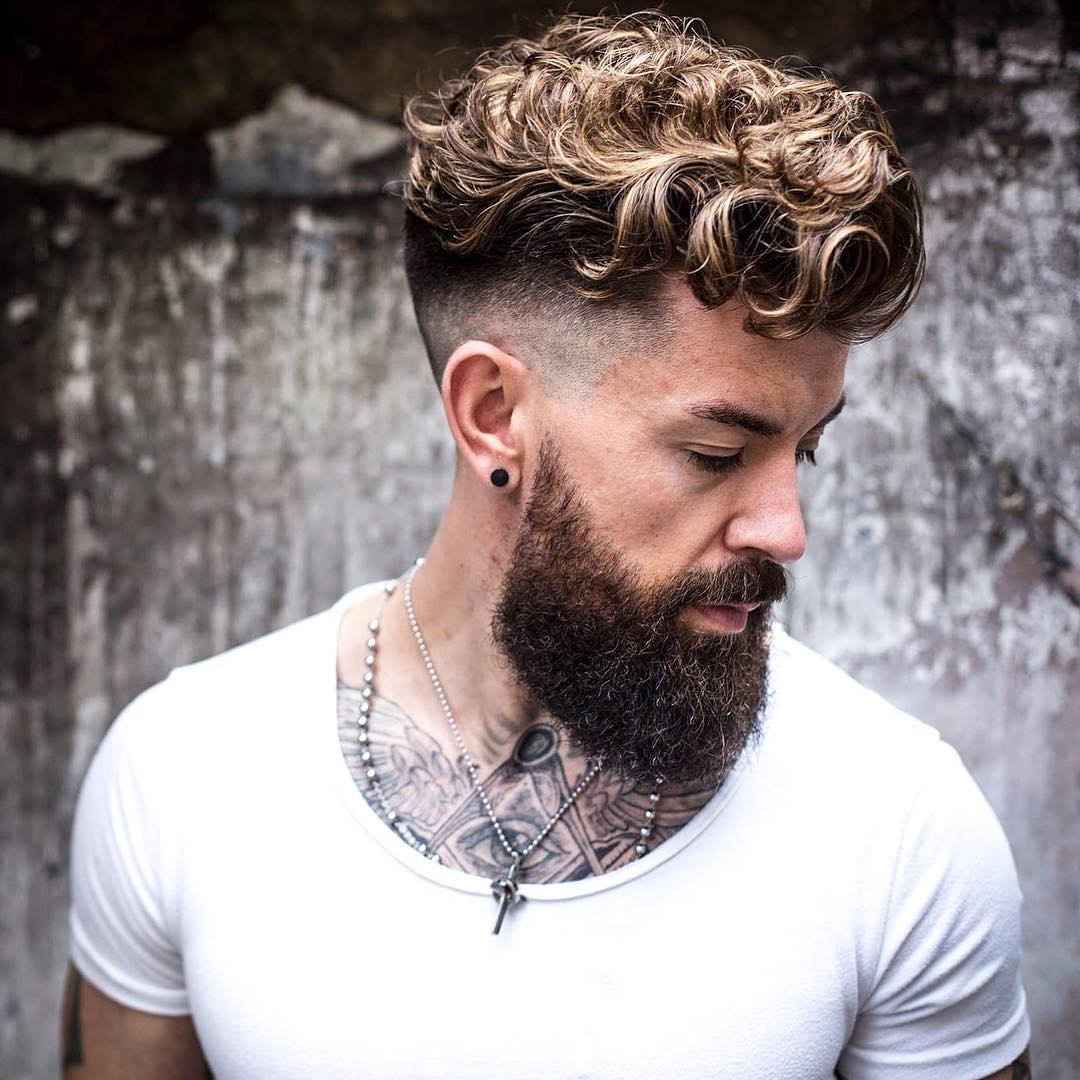 a curly undercut haircut with a high skin fade that creates a sharp contrast with curly hair