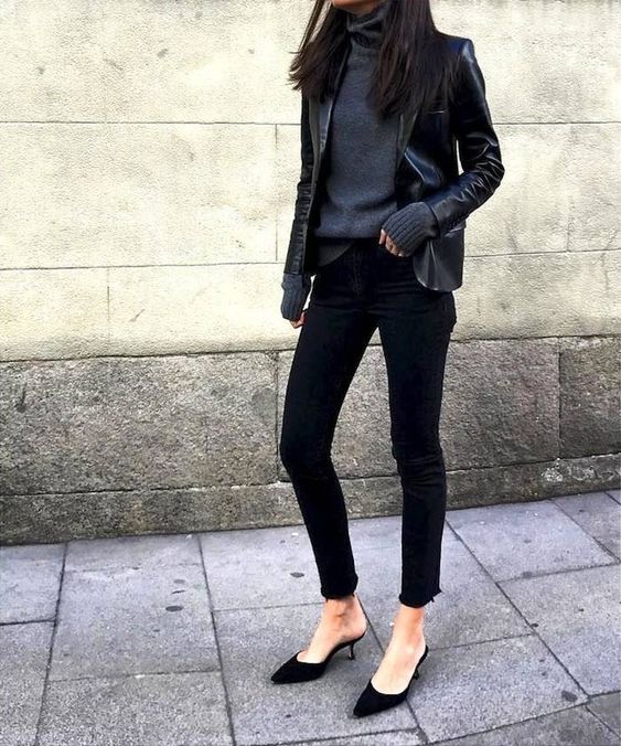 a total black look with a turtleneck sweater, a black leather jacket, black jeans and black pointed shoes