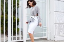 With gray shirt, white knee-length skirt and beige pumps
