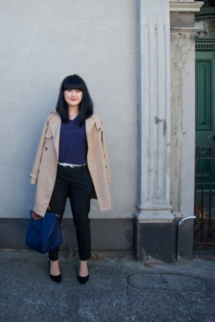With navy blue blouse, black trousers, beige coat, black shoes and navy blue tote