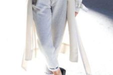 With white sweater, black embellished shoes, beige coat and light gray pants