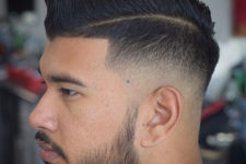 a low razor fade with hard part comb over and a beard is a bold and eye-catchy idea