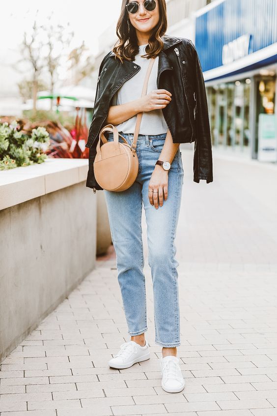 a white tee, blue jeans, white sneakers, a black leather jacket, a tan bag for a trendy spring casual outfit