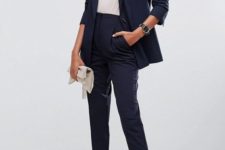 03 a navy pantsuit with cropped pants, a white top, black heels and a white tassel clutch