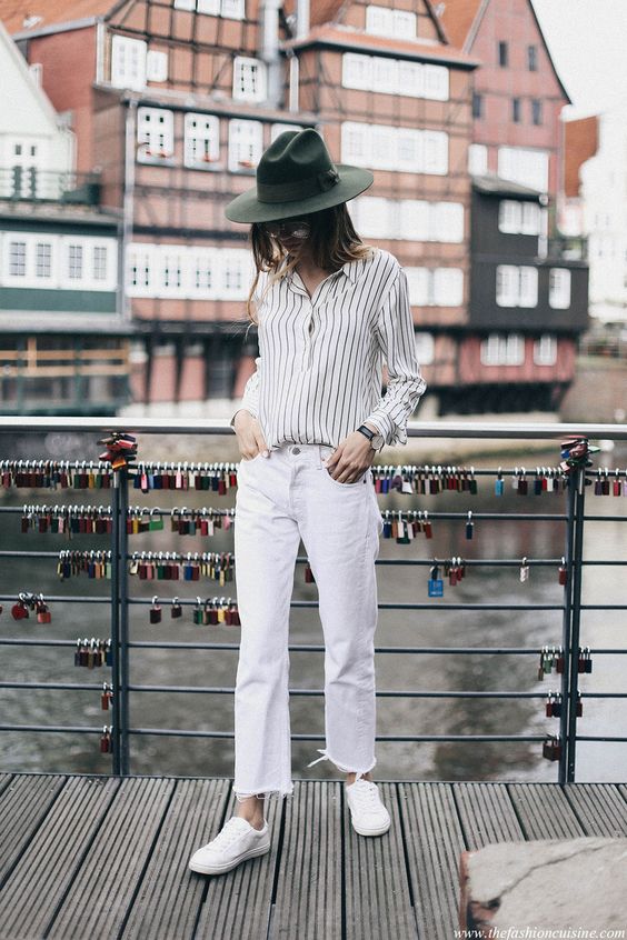 white jeans, a striped shirt, white sneakers and a black hat for spring