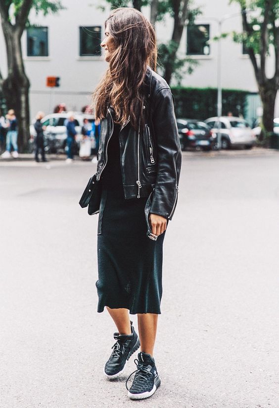 a black casual midi dress, an oversized black leather jacket and black sneakers plus a clutch