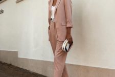 06 a blush pantsuit with an oversized blazer, a white top, silver shoes and a small clutch