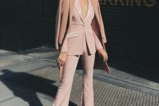 12 a blush pantsuit with shiny detailing, no top under and white shoes plus statement earrings
