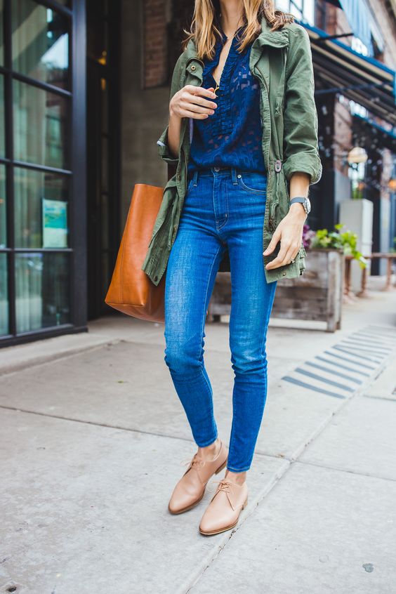 a navy lace shirt, blue skinnies, tan Oxford shoes, an olive green jacket and an amber tote