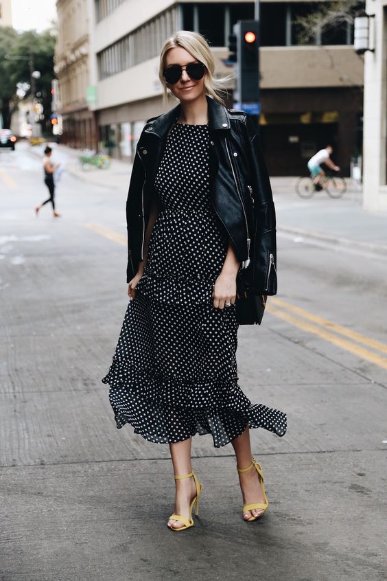 a black and white polka dot ruffled midi dress, a black leather jacket and yellow shoes