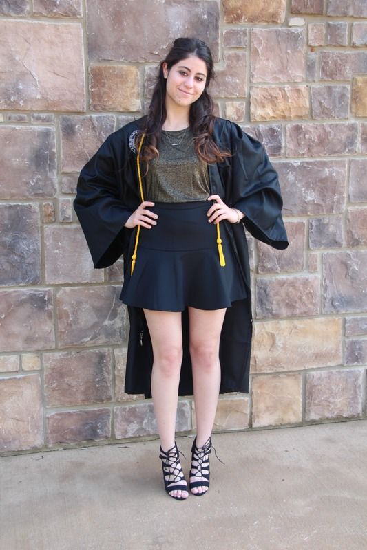 a black ruffled high waist skirt, a metallic top, lace up shoes and a college gown on top