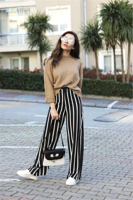 With camel sweater, white sneakers and black and white bag