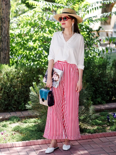 With white button down loose shirt, wide brim hat, three colored bag and white flat mules