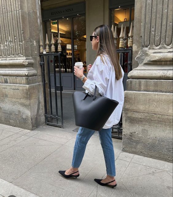 a casual look with a white oversized button down, blue jeans, black slingbacks and a large black tote
