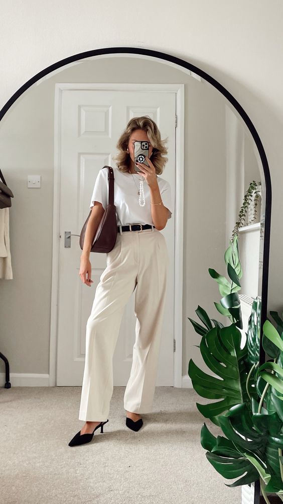 a classy work look with a white tee, neutral pants, a black belt, black slingbacks and a brown hobo bag