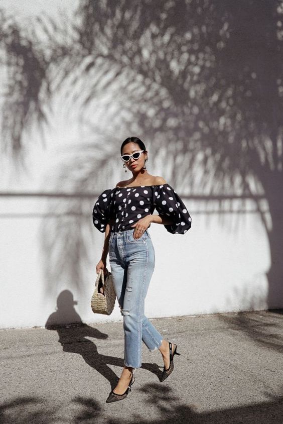 a refined and girlish summer look with a black off the shoulder top, bleached jeans, black slingbacks and a woven bag