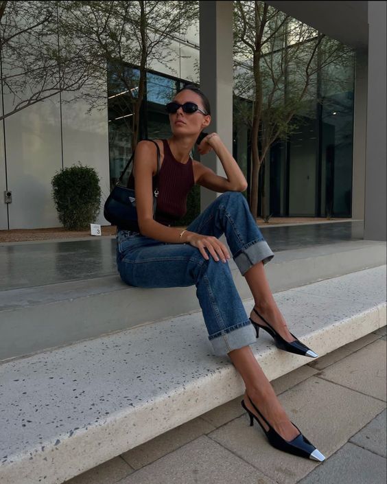 a summer outfit with a burgundy halter neck top, blue jeans, slingbacks and a black baguette bag