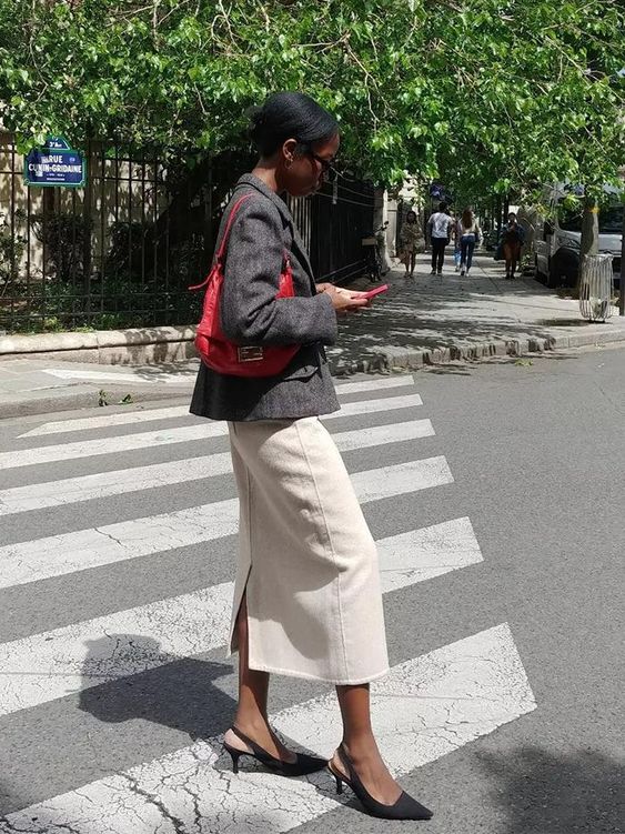 a work outfit with a white midi skirt, a grey blazer, a red hobo bag and black slingbacks is great for spring