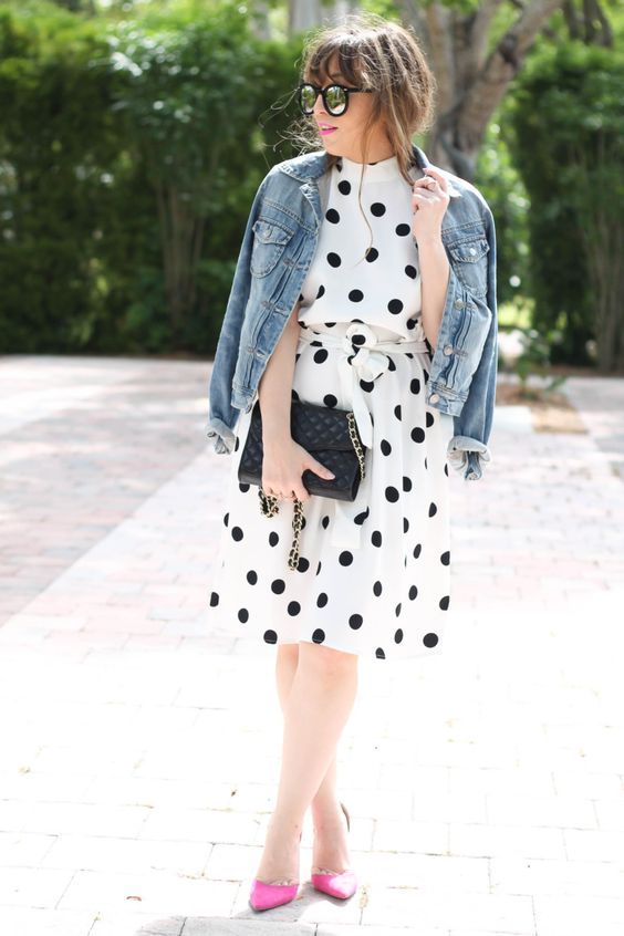 a black and white polka dot knee dress, a denim jacket and neon pink shoes for a modenr touch