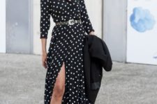 07 a black and white polka dot midi dress with a front slit, long sleeves, red platform shoes and a black trench