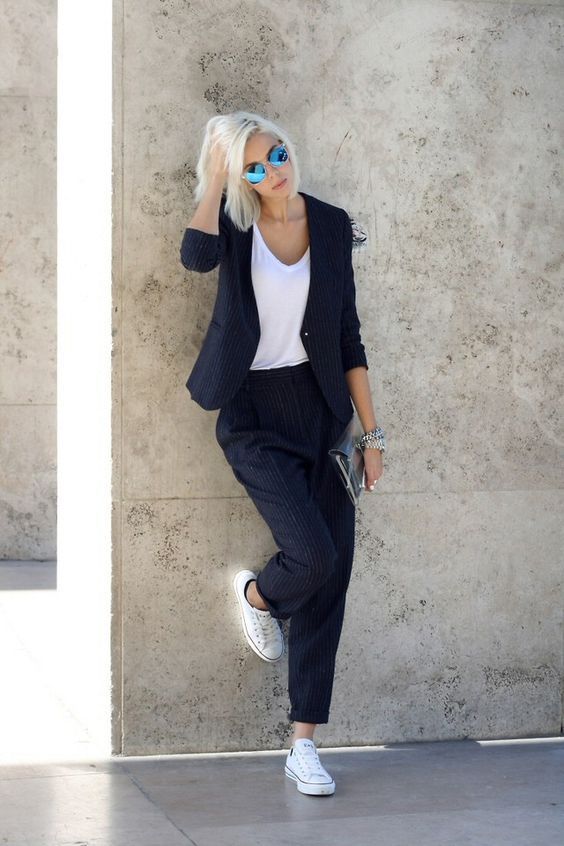 a black thin striped pantsuit, a white tee and white sneakers for a monochromatic work look