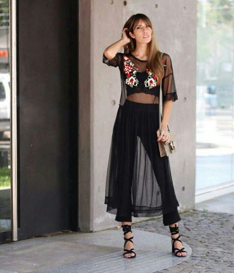 With black flare pants, lace up heels and bag