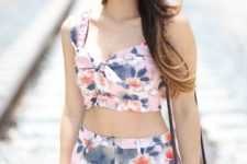 With floral shorts, rounded sunglasses and small bag