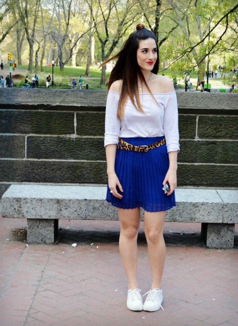 With white off-the-shoulder shirt, blue pleated skirt and white sneakers