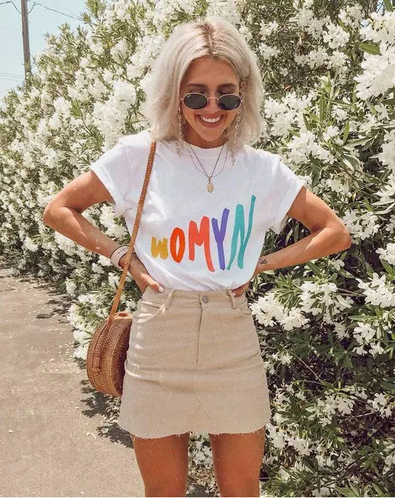 A bright printed t shirt, a tan denim mini skirt, a wooden round crossbody bag for summer