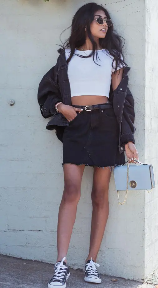 a monochromatic look with a white crop top, an oversized denim jacket, a mini skirt, black sneakers and a necklace