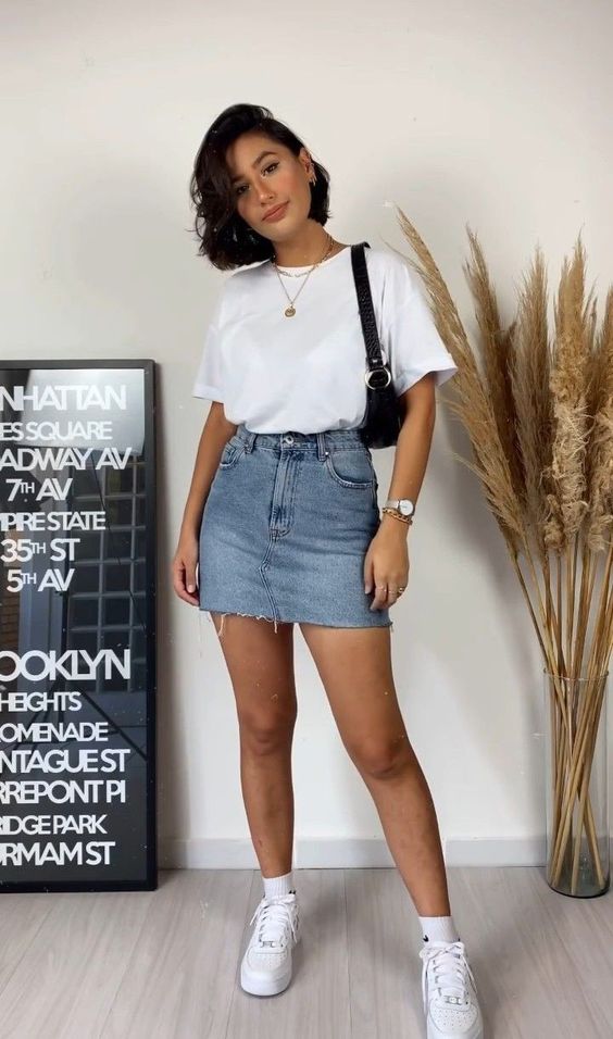a simple summer look with a white tee, sneakers and socks, a blue denim mini, a black baguette bag