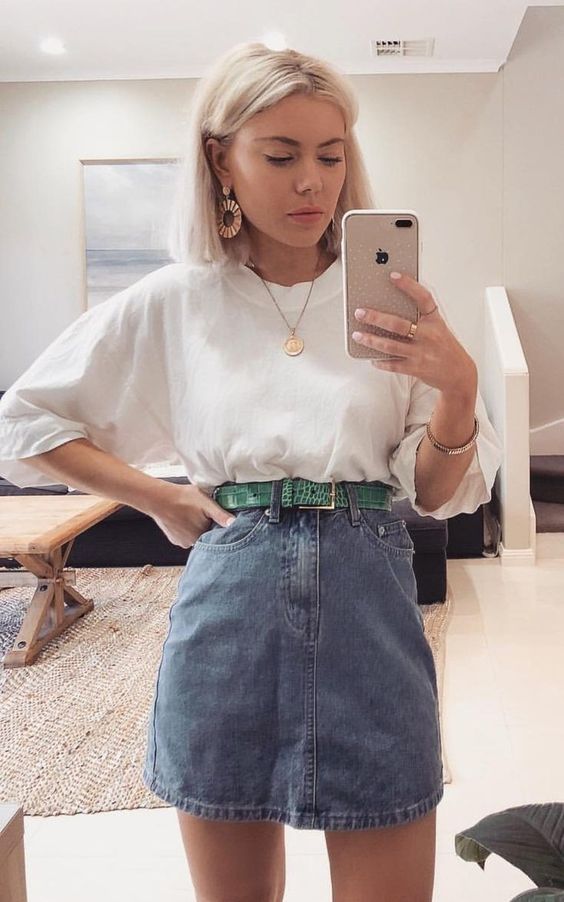a simple summer outfit with an oversized white tee, a blue denim mini, a green belt, statement jewelry