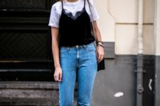 a white tee, a black velvet top, blue mom jeans, black sneakers and a black bag