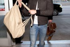 a white tee, blue jeans, brown boots and a brown checked bomber jacket plus a tan backpack