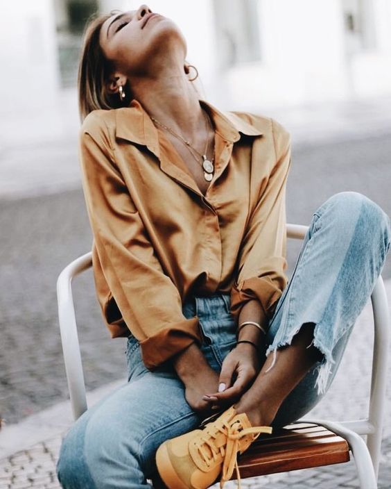 a yellow silk button down, blue jeans with a raw hem, yellow sneakers for a boho feel