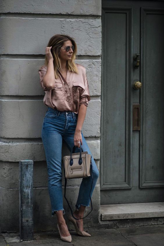 an oversized dusty pink shirt, blue jeans with a raw hem, nude shoes and a nude and black bag